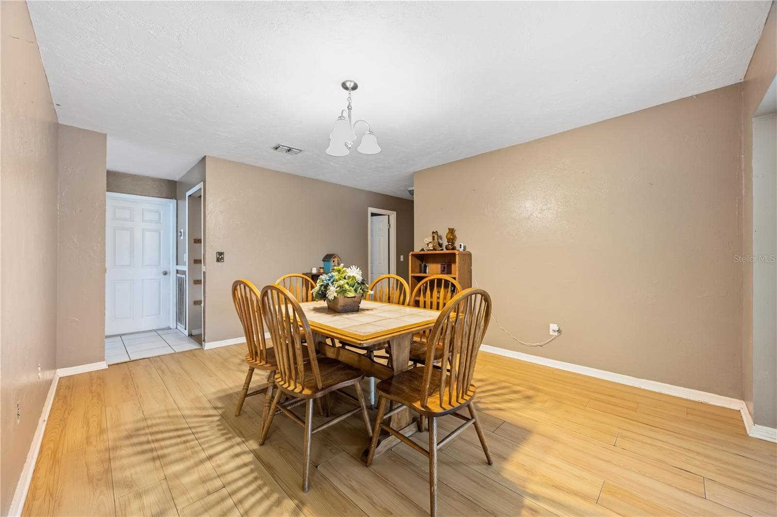 Versatile dining area offering smooth flow into the kitchen, large sliding glass doors leading out to the lanai, and an open entryway to the main living room. - 3906 SANTIAGO ST, SEBRING