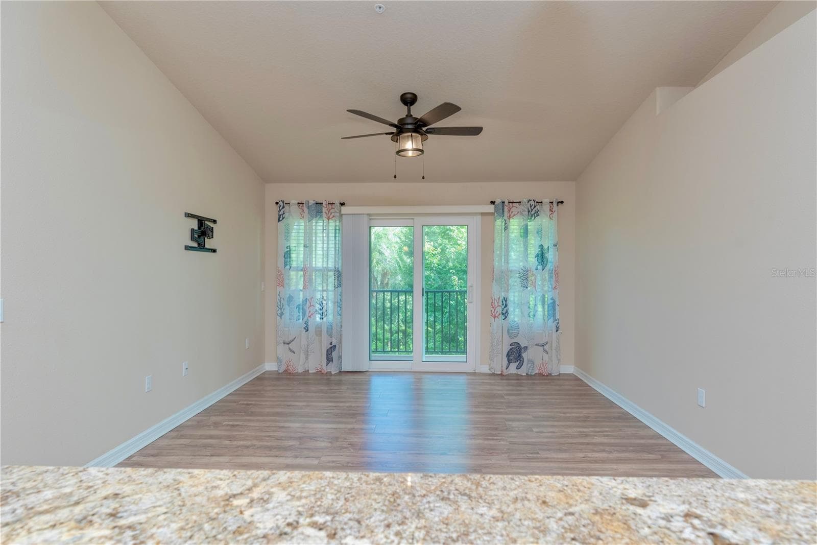 French doors leading to the covered balcony with view of trees. - 5065 ROYAL PALMS WAY #303, NEW PORT RICHEY