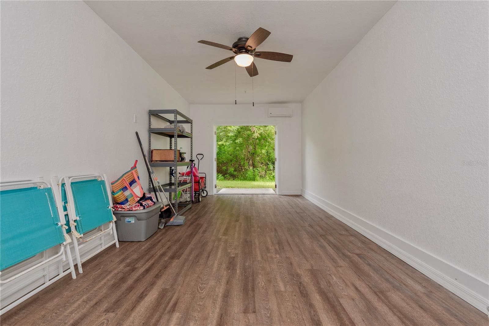 Downstairs storage room has French doors leading to a small patio and has a tree view. - 5065 ROYAL PALMS WAY #303, NEW PORT RICHEY