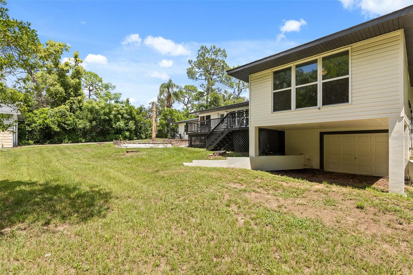 Back of house with lower garage - 1602 COUNTRY CLUB RD, EUSTIS