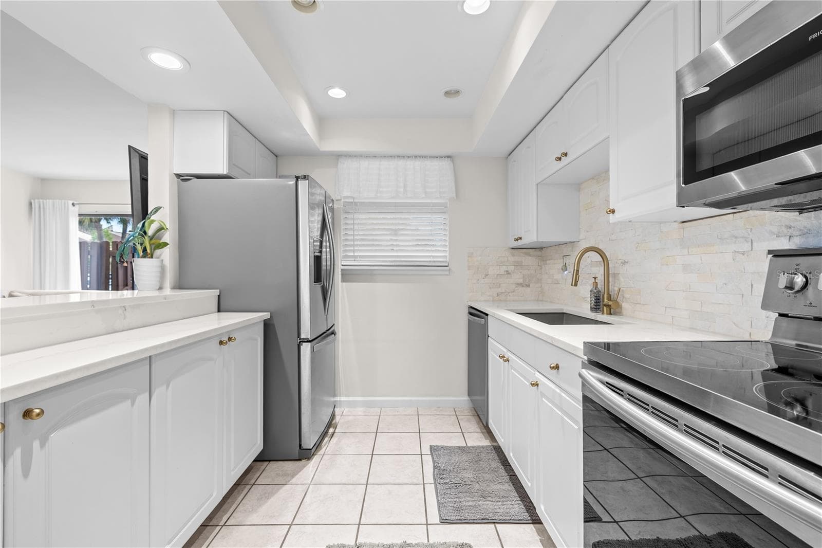 This stunning unit features a remodeled kitchen with stainless steel appliances, including dishwasher - 782 VILLAGE LAKE TER N #103, ST PETERSBURG