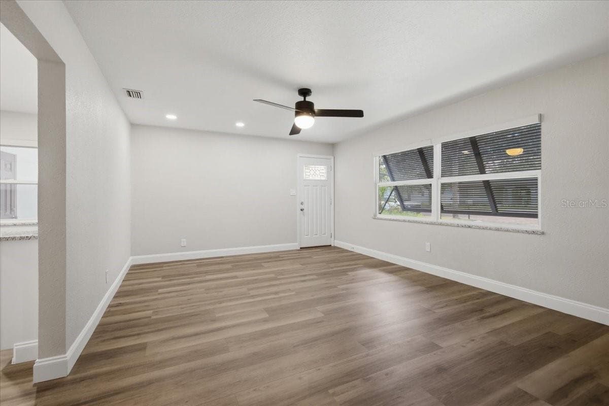 Spacious Living Room with Hurricane Shutters & Remote-Controlled Blinds Throughout - 1837 PASADENA DR, DUNEDIN