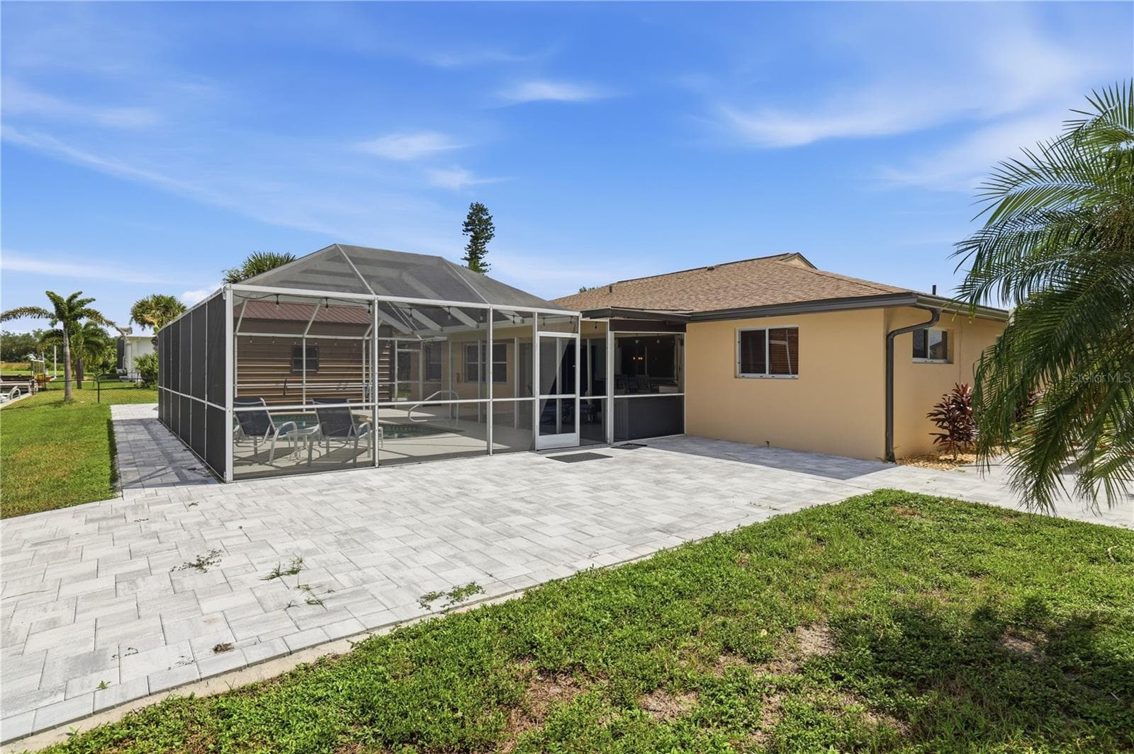 Pavers on back side of home, room for a hot tub there, outside sunning chairs, fire pit. - 136 SINCLAIR ST SE, PORT CHARLOTTE