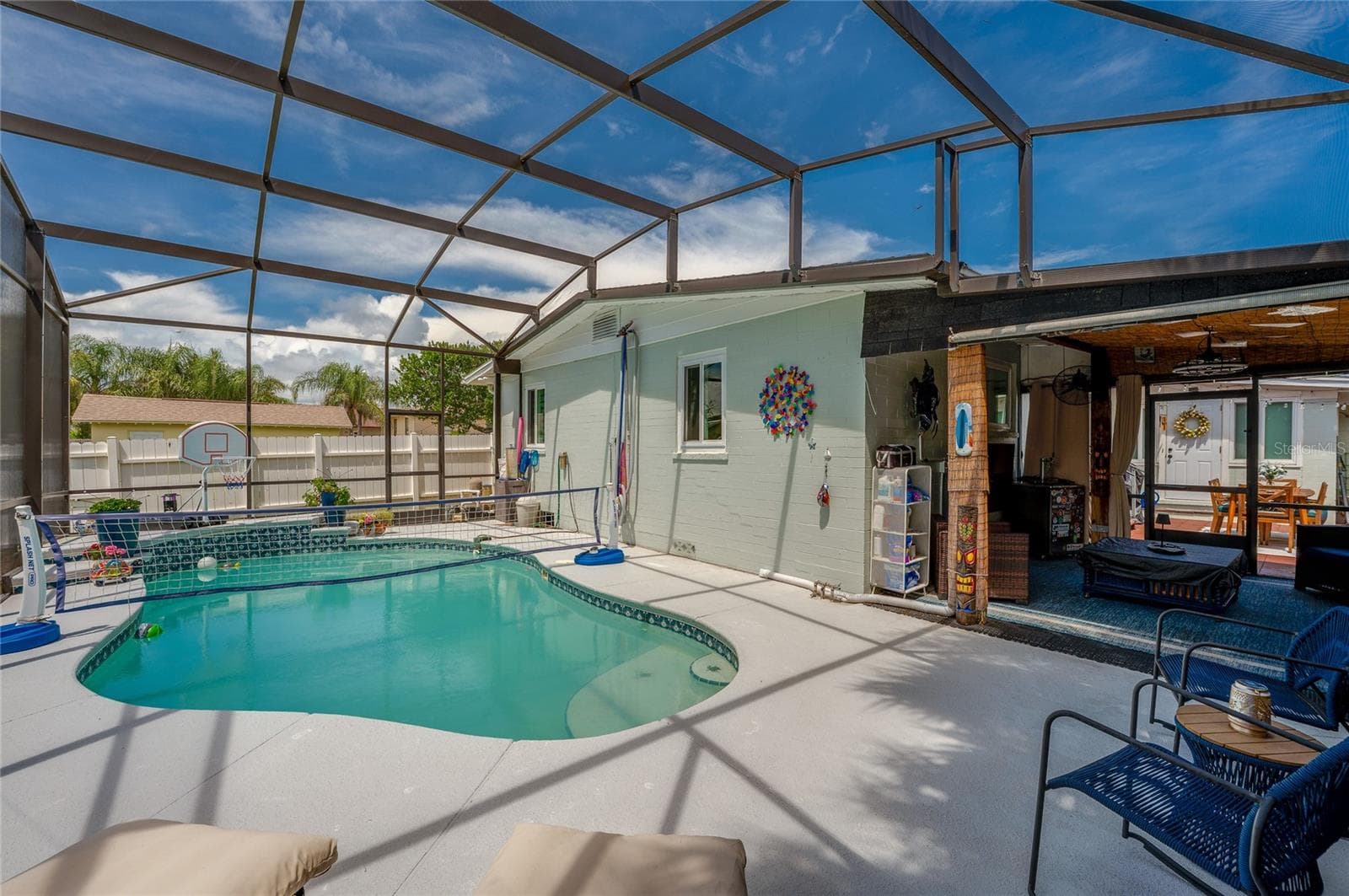 Spacious screened enclosure surrounding a custom in-ground pool with built-in steps. The layout seamlessly blends covered patio living with open-air sunbathing space. - 348 WOODLAND AVE, DAYTONA BEACH