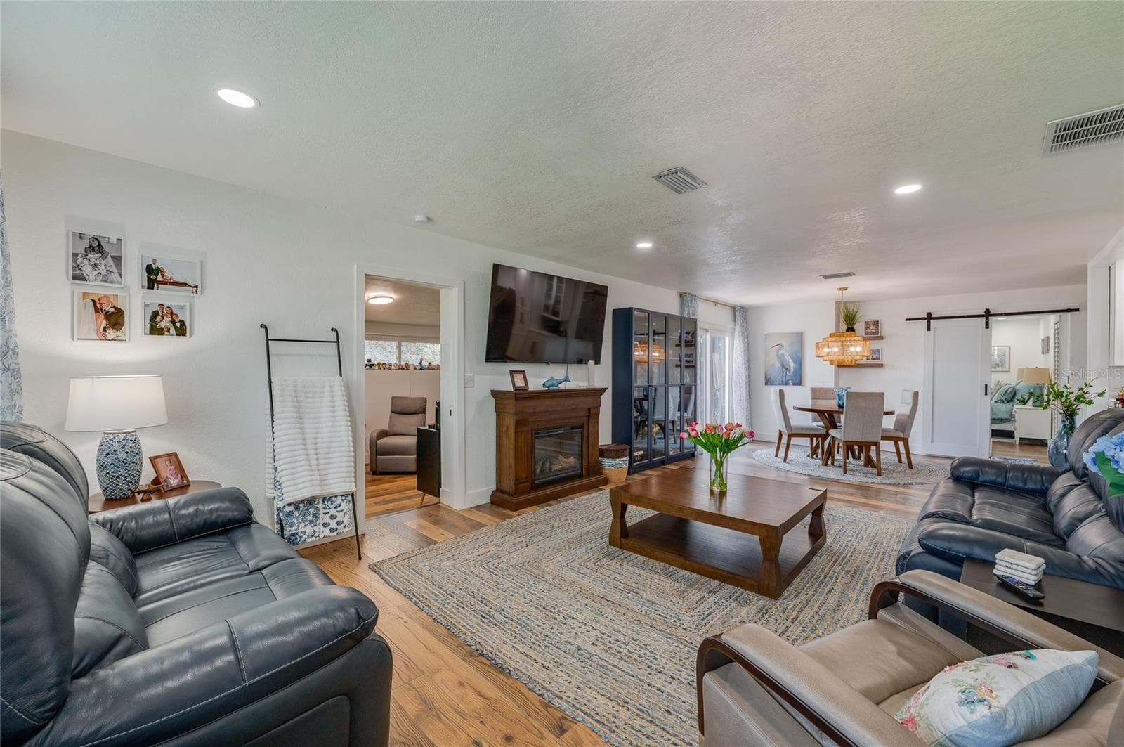 Spacious open-concept living area with warm LVP flooring, recessed lighting. - 348 WOODLAND AVE, DAYTONA BEACH