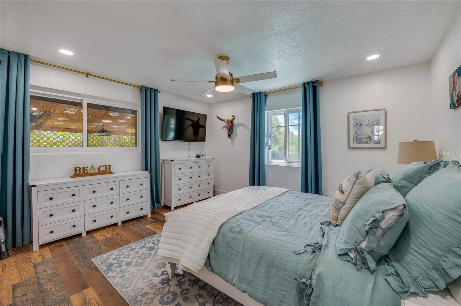 Light-filled bedroom featuring double windows, LVP flooring, and recessed ceiling lighting with a matching ceiling fan. - 348 WOODLAND AVE, DAYTONA BEACH