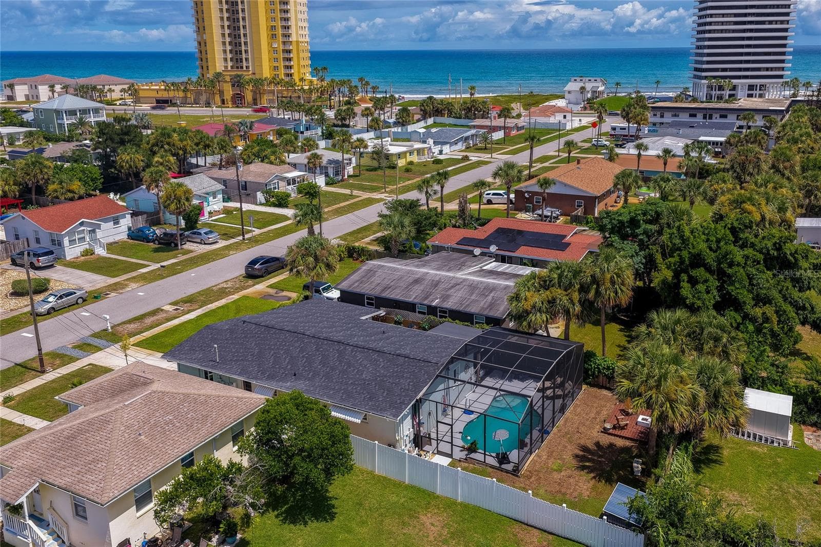 High-angle aerial photo displaying the home’s layout, complete with its screened-in pool area, private yard, and proximity to the coastline. - 348 WOODLAND AVE, DAYTONA BEACH