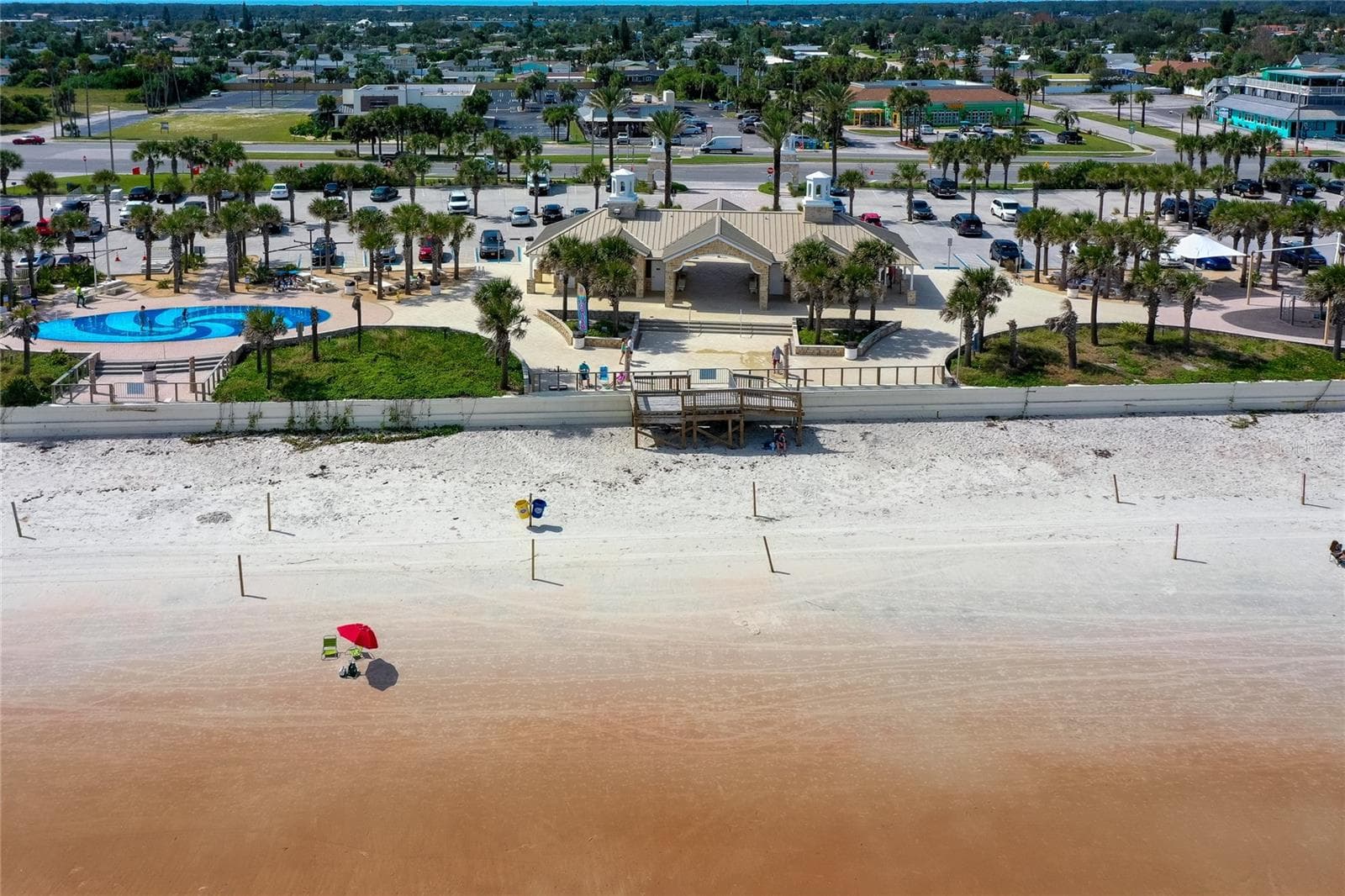 Aerial view showcases nearby Andy Romano Beachfront Park with direct Atlantic Ocean access, beachfront facilities, palm-lined grounds, and convenient parking. - 348 WOODLAND AVE, DAYTONA BEACH