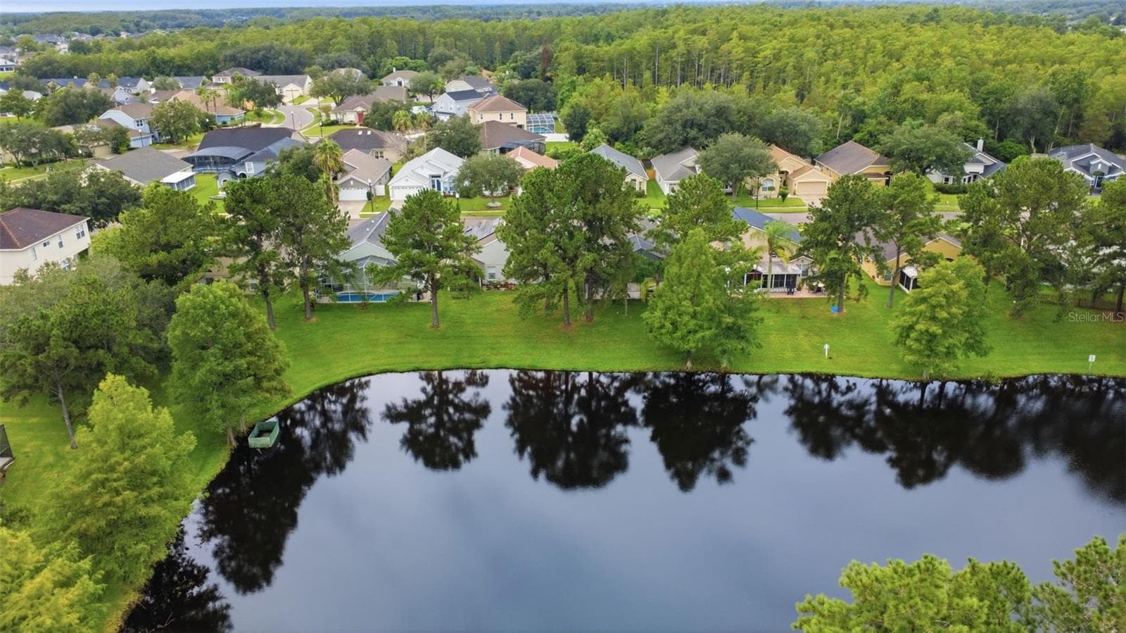 Aerial view showcasing the home's pond-side setting within the surrounding Waterford Lakes community. - 13637 EMERALDVIEW DR, ORLANDO