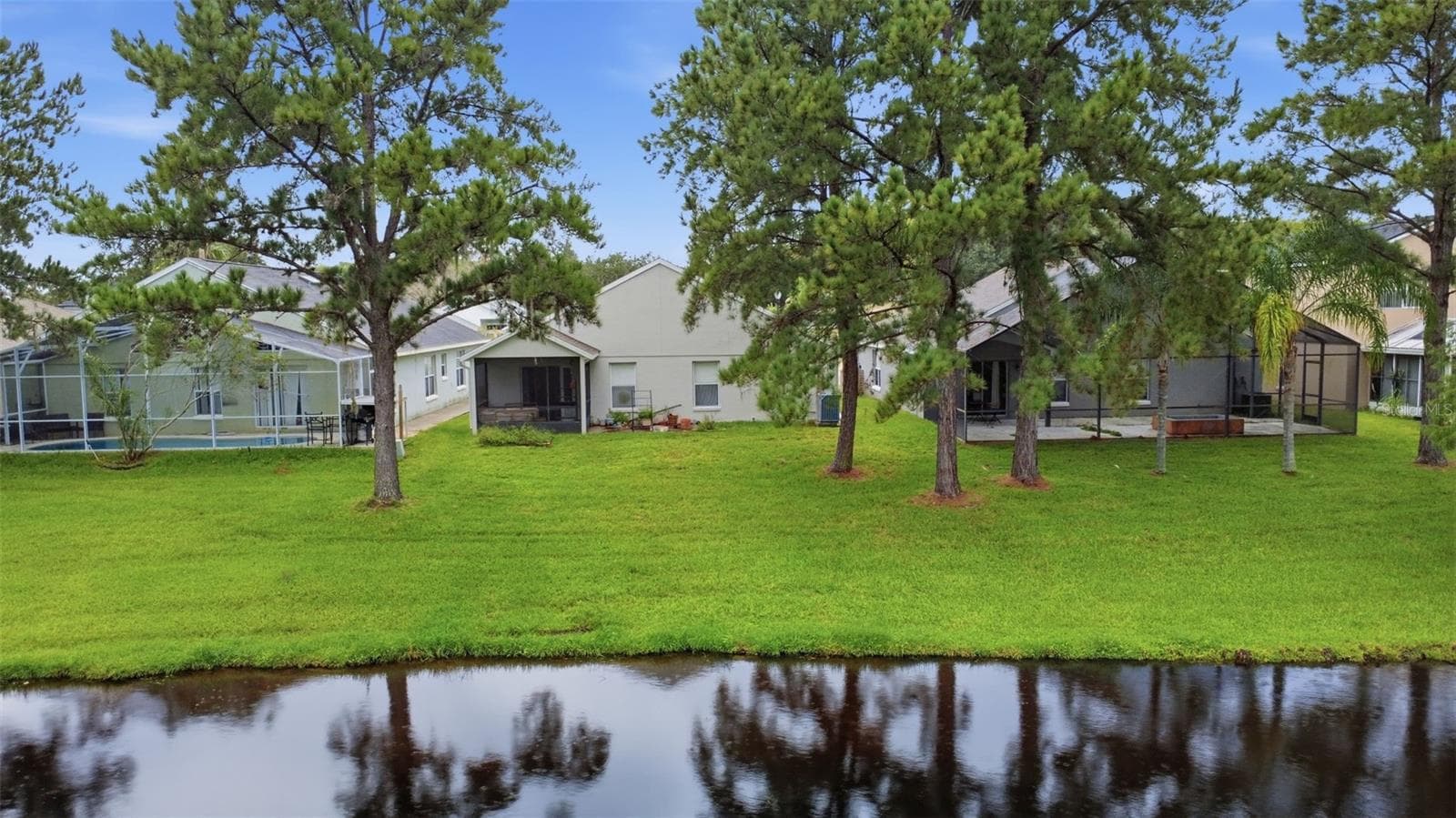 Pond-side view of the property highlights the home's peaceful setting - 13637 EMERALDVIEW DR, ORLANDO