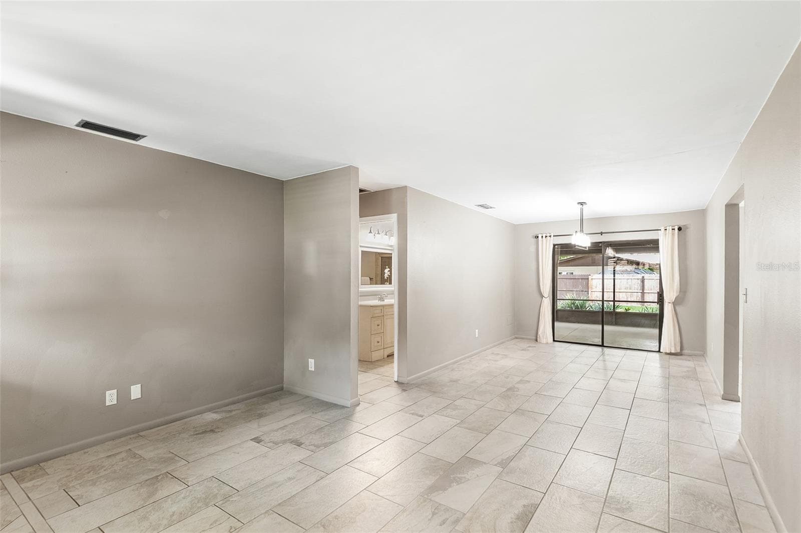 Living Room and Dining Room. Sliders lead to covered & screened in room - 216 SHORE LOOP, WINTER HAVEN