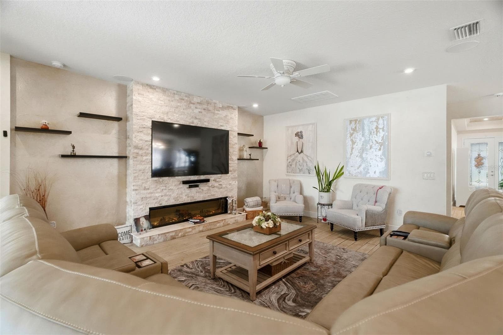 Spacious living area with recessed lighting, custom wall finishes and direct flow into the kitchen.Bright, open living room with large-format tile flooring and custom interior finishes. - 11750 LAKE LUCAYA DR, RIVERVIEW