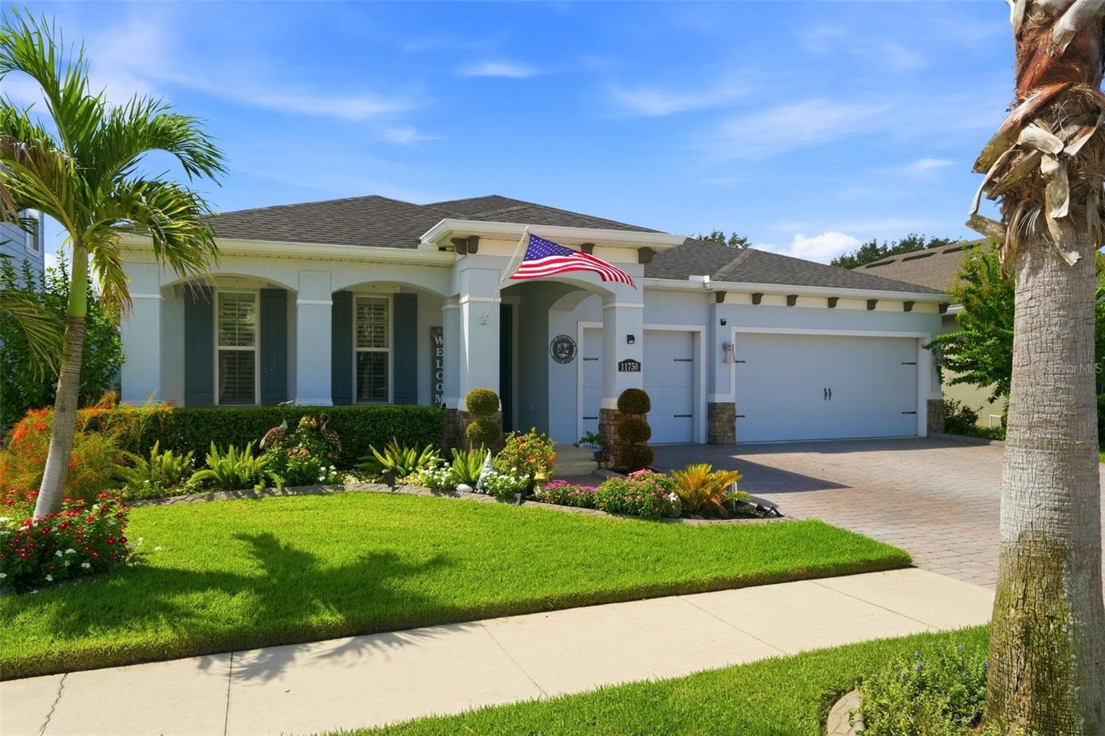 Custom modern farmhouse shutters, added gutters, decorative landscape curbing and manicured landscaping enhance the exterior. - 11750 LAKE LUCAYA DR, RIVERVIEW