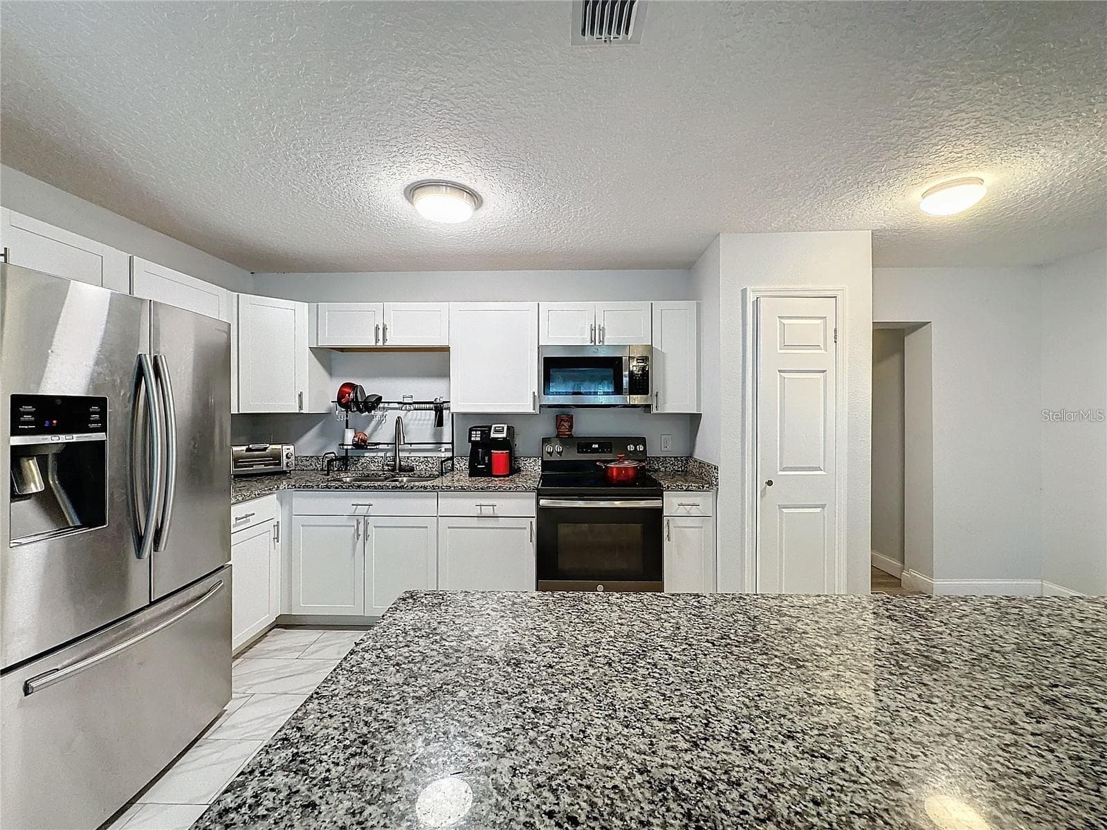 FRONT ANGLE KITCHEN FROM FRONT GRANITE ISLAND - 7211 PINION DR, ORLANDO