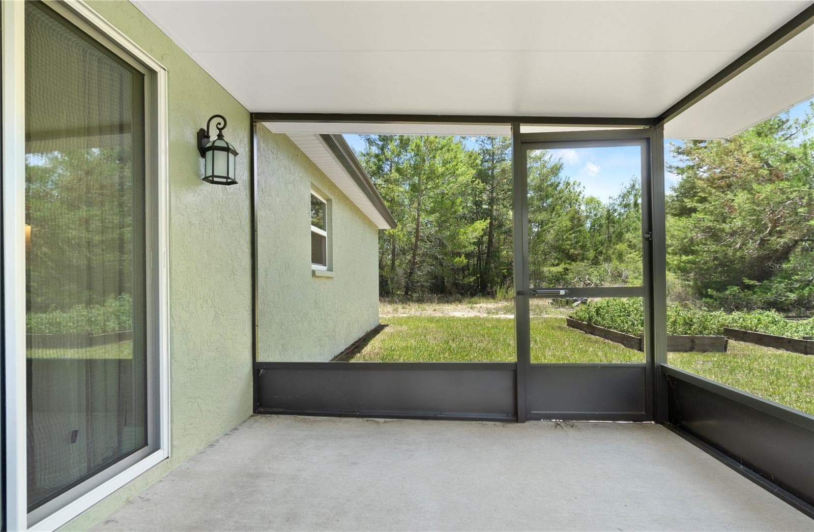 Screened back patio accessed via sliding glass doors — perfect for peaceful afternoons. - 15994 SW 55TH AVENUE RD, OCALA