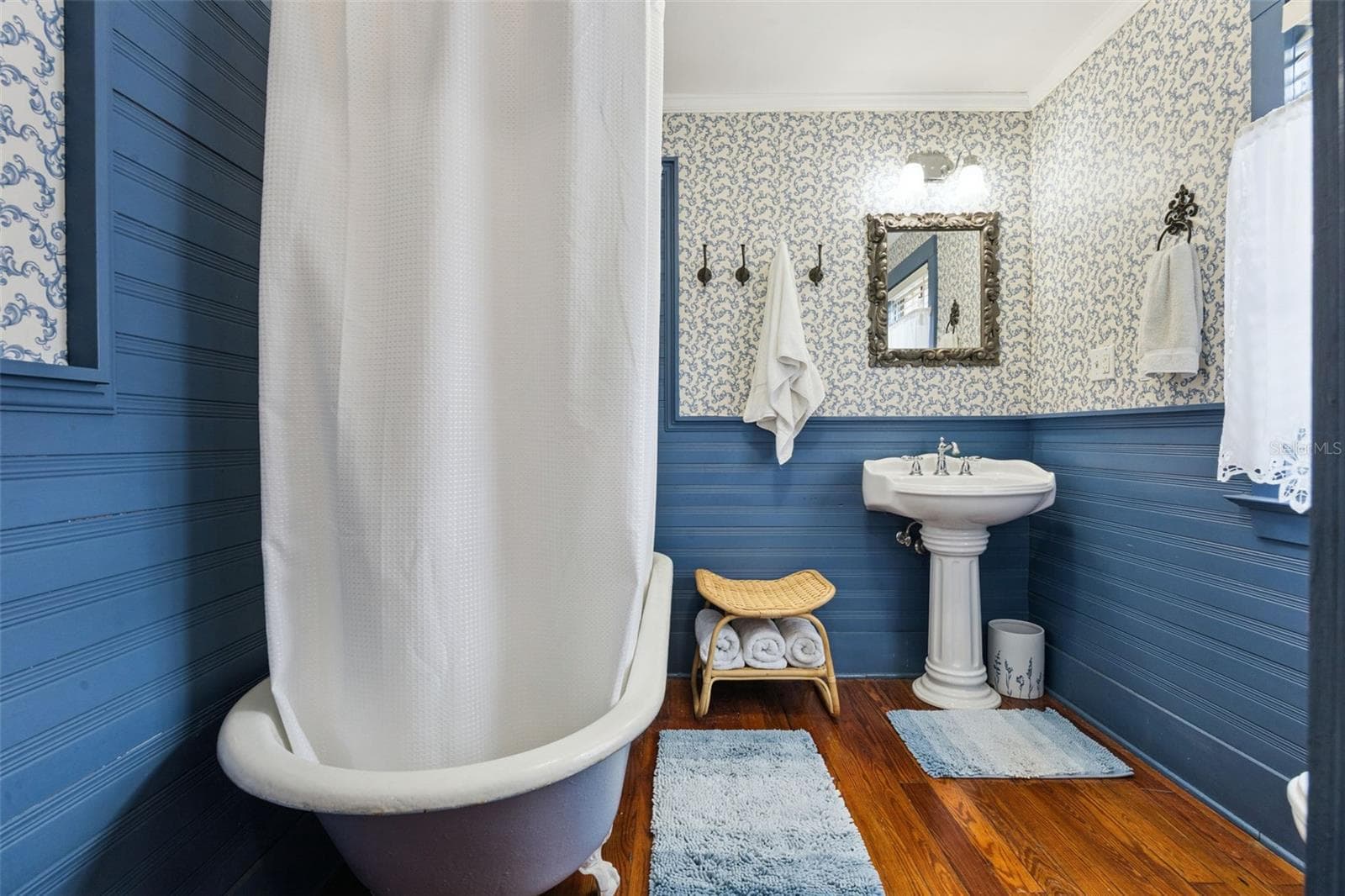 Vintage character continues in the bath with a clawfoot tub, pedestal sink, beadboard detailing and wood floors. - 2201 CELERY AVE, SANFORD