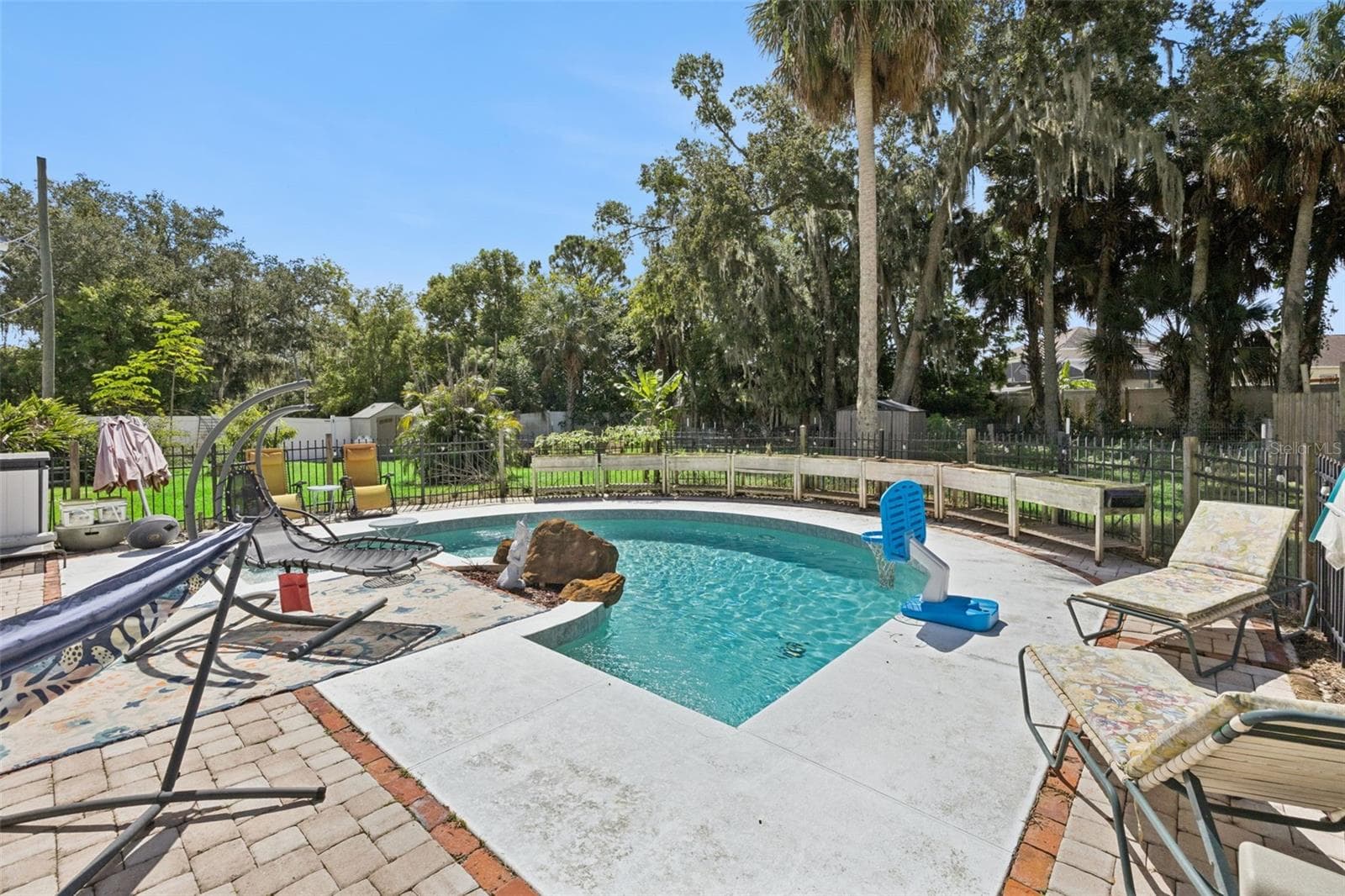 The saltwater pool is surrounded by mature trees and opens naturally to the property's unusually generous backyard. - 2201 CELERY AVE, SANFORD
