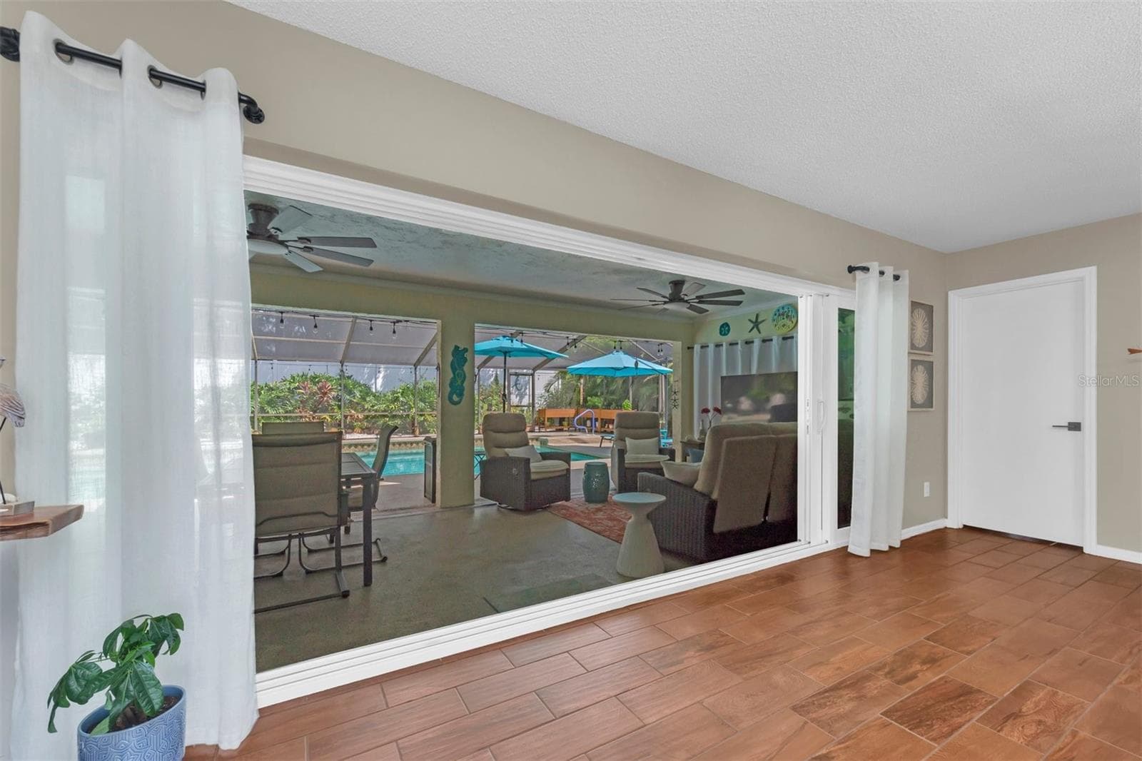 IMPACT POCKET DOORS OPEN TO SCREENED LANAI - 207 AMESBURY CIR, SUN CITY CENTER
