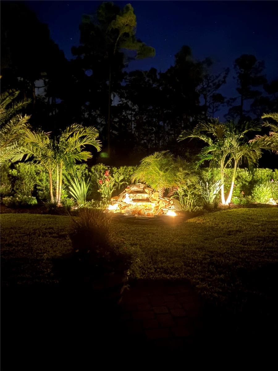 Backyard fountain at night - 2511 PINE PRESERVE CT, ST CLOUD