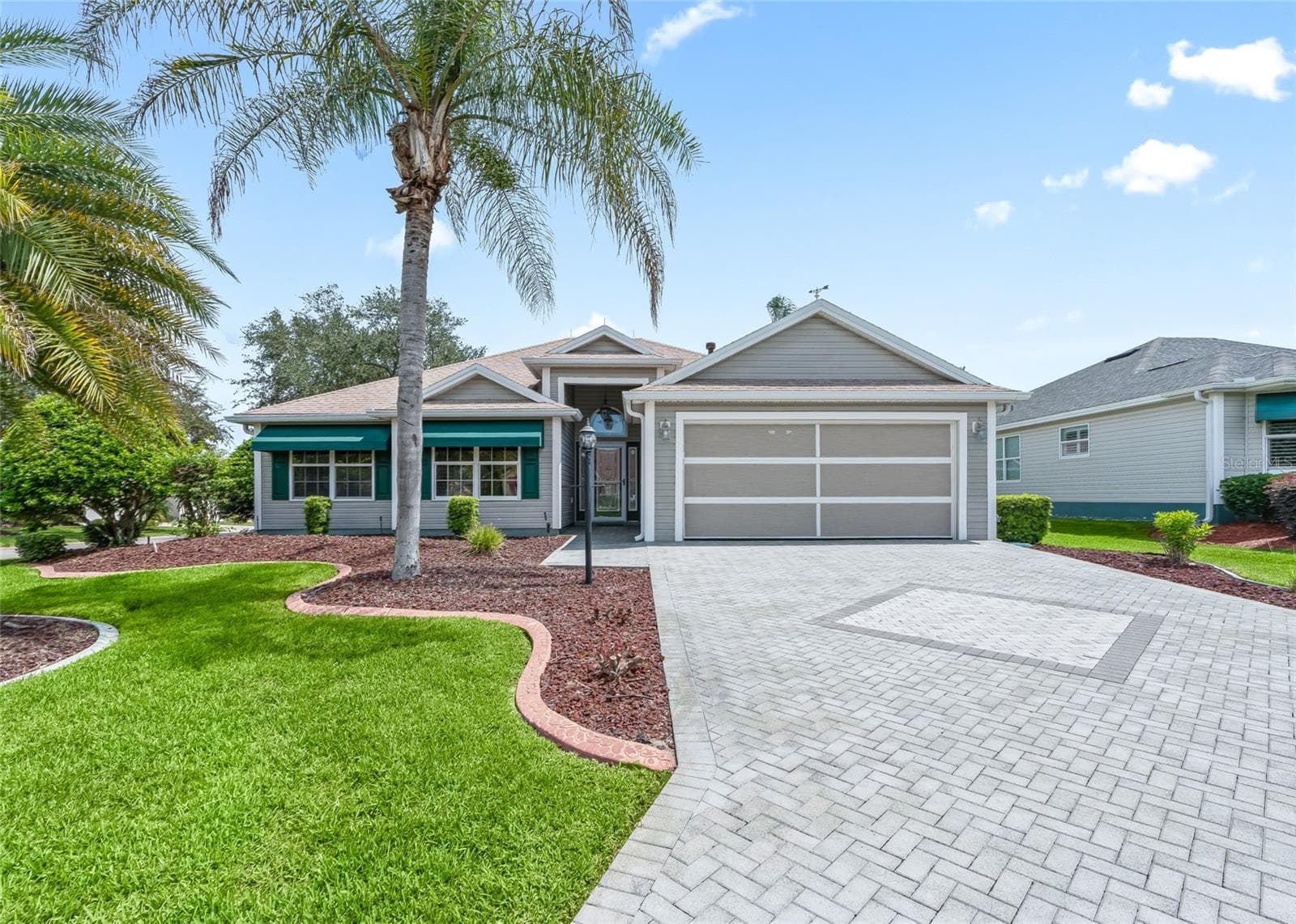 Wonderful curb appeal with a custom paver driveway, mature landscaping, palm trees and an inviting covered entry. - 17601 SE 81ST TIMBERWOOD TER, THE VILLAGES