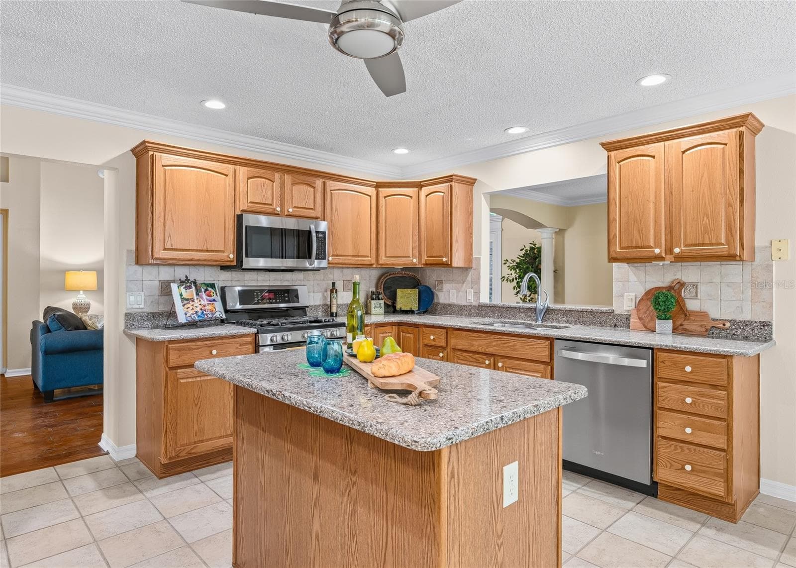 Large kitchen features abundant wood cabinetry, generous counter space, center island, stainless steel appliances, tile backsplash, recessed lighting and crown molding. - 17601 SE 81ST TIMBERWOOD TER, THE VILLAGES