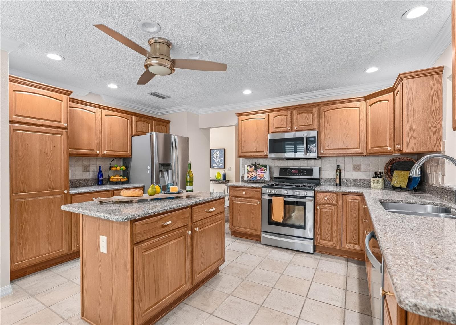 A closer look at the well-designed kitchen with extensive cabinetry, granite-look counters, center island, stainless steel appliances and plenty of workspace. - 17601 SE 81ST TIMBERWOOD TER, THE VILLAGES