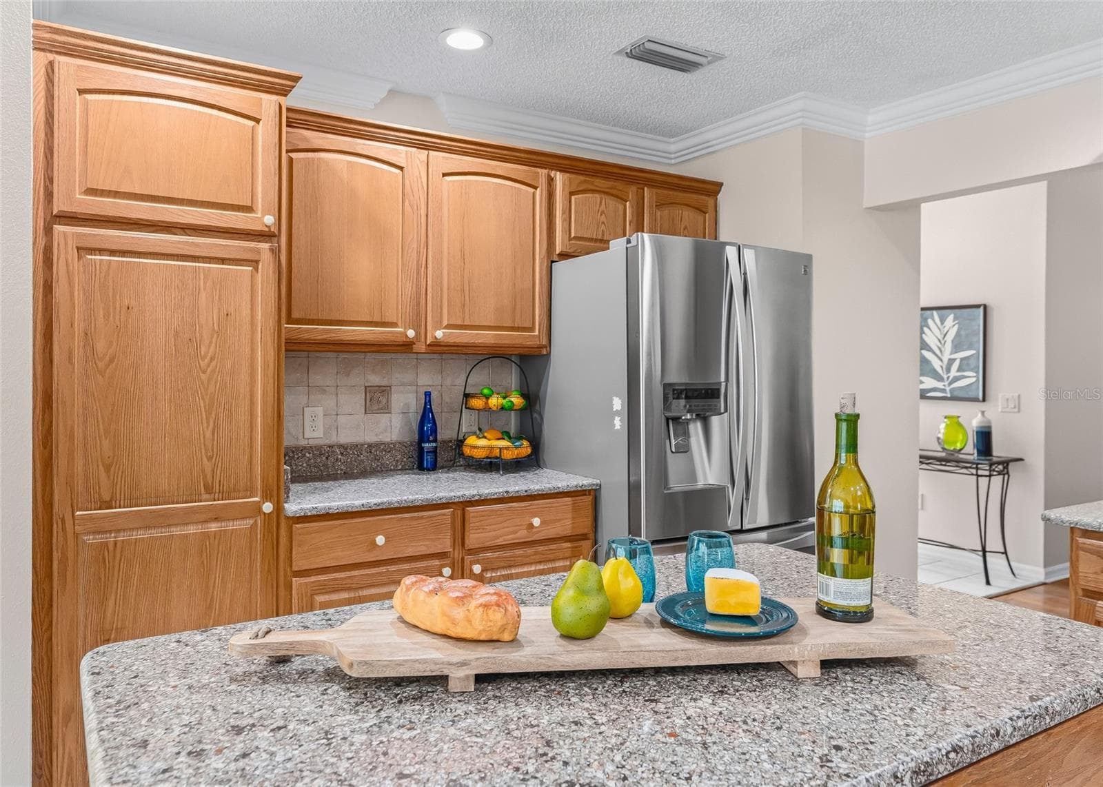 Excellent kitchen storage with tall pantry-style cabinetry, additional counter space and a large center island—ideal for food preparation and casual entertaining. - 17601 SE 81ST TIMBERWOOD TER, THE VILLAGES