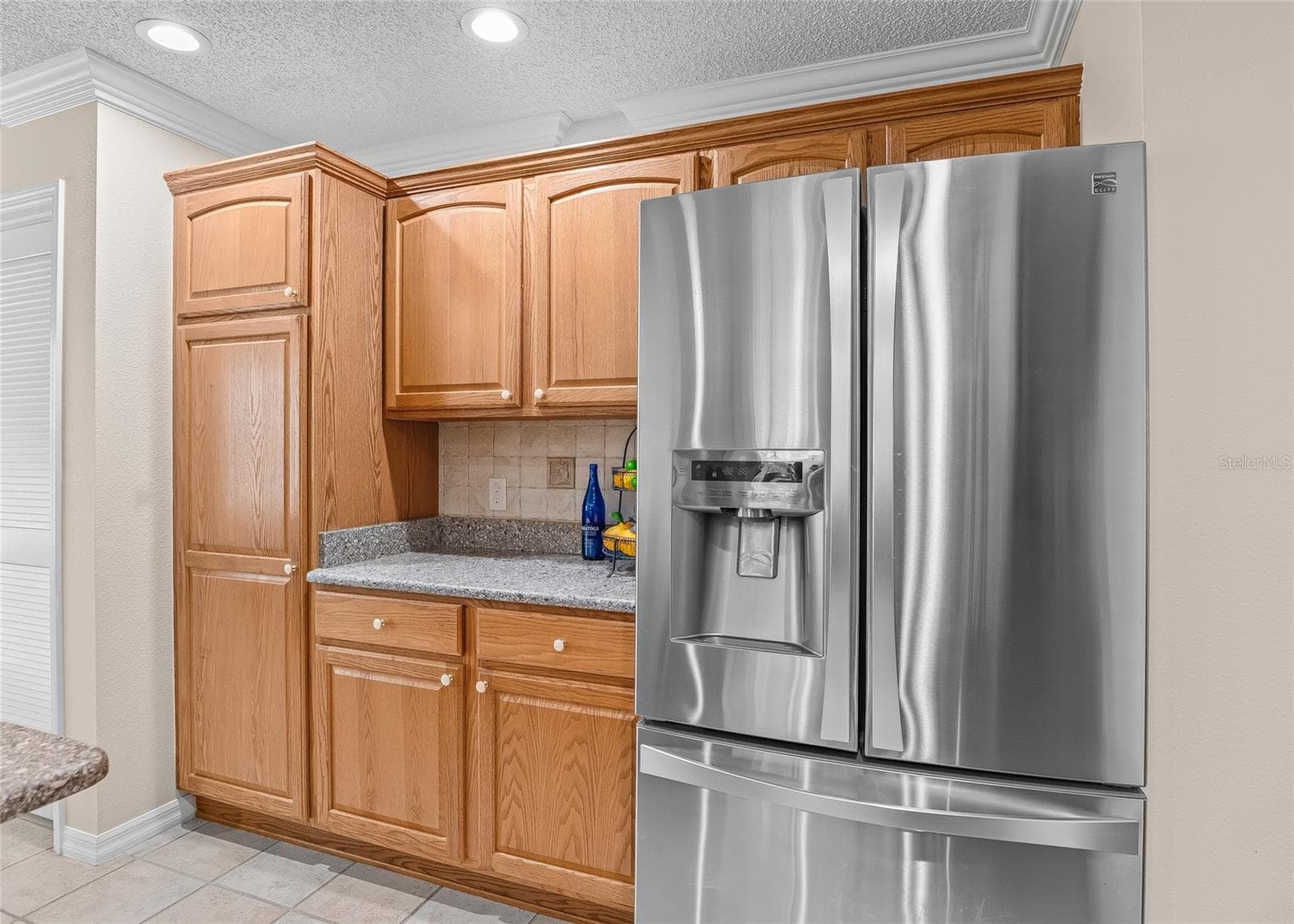 Additional cabinetry surrounding the stainless French-door refrigerator provides exceptional storage and extra countertop space. - 17601 SE 81ST TIMBERWOOD TER, THE VILLAGES