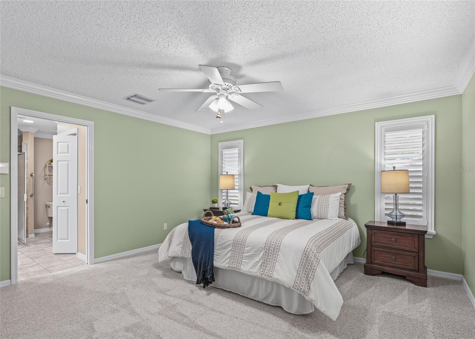 Another view of the generous Primary Suite highlights the abundant floor space, plantation shutters and convenient access to the ensuite bath. - 17601 SE 81ST TIMBERWOOD TER, THE VILLAGES