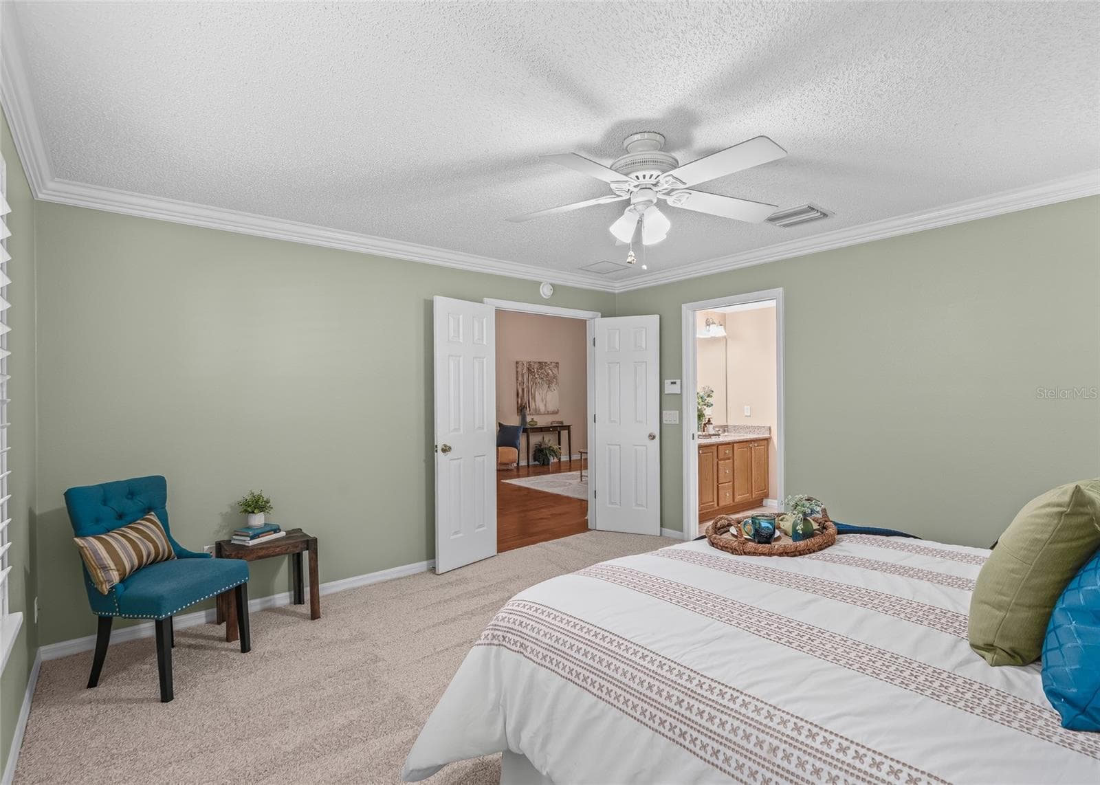 The expanded Primary Bedroom offers plenty of room for a king-size bed and additional furniture, with crown molding and fresh carpeting adding a polished finish. - 17601 SE 81ST TIMBERWOOD TER, THE VILLAGES
