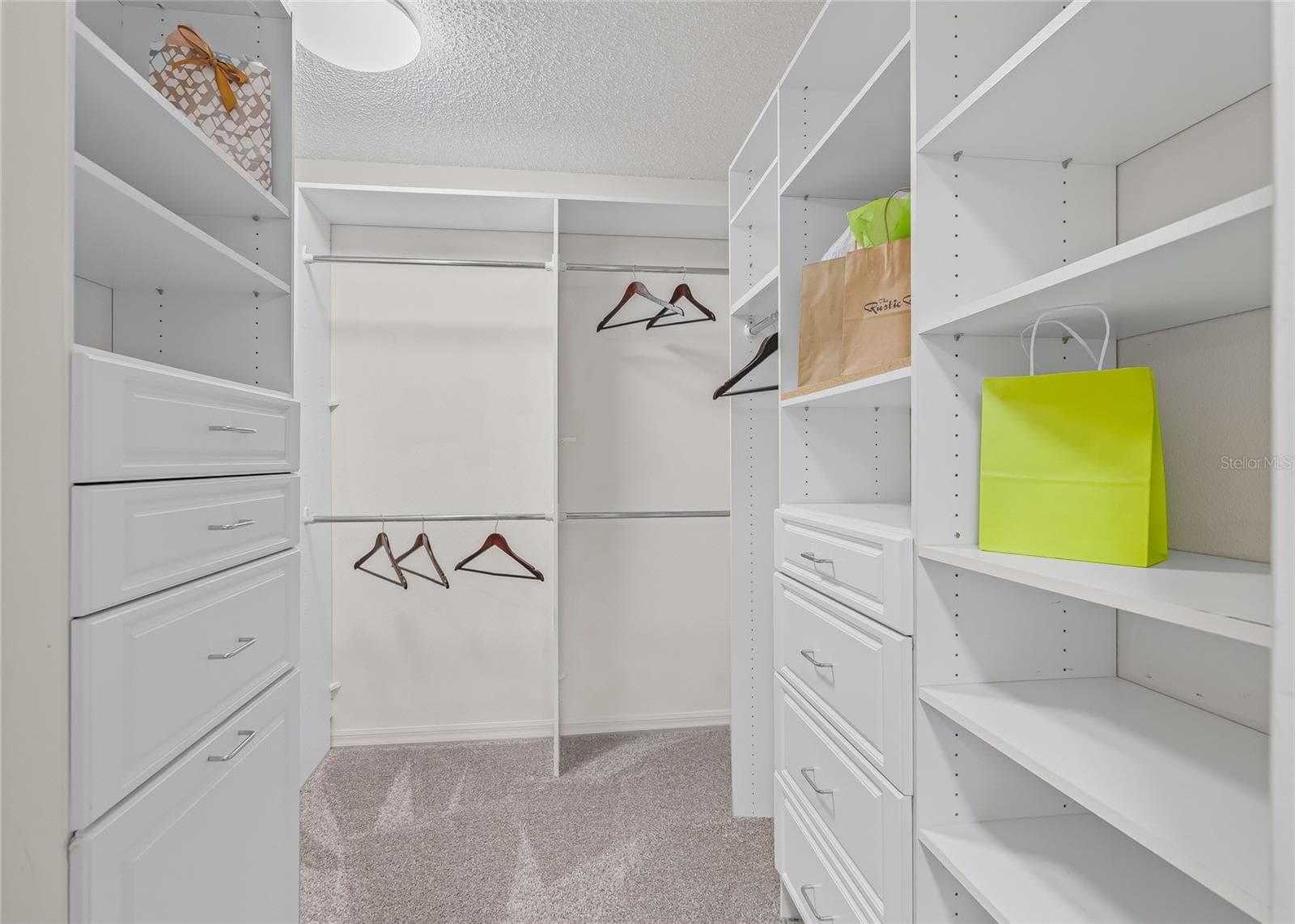Large CUSTOM WALK-IN CLOSET with extensive built-in shelving, hanging space and drawer storage—designed to keep everything organized and easily accessible. - 17601 SE 81ST TIMBERWOOD TER, THE VILLAGES