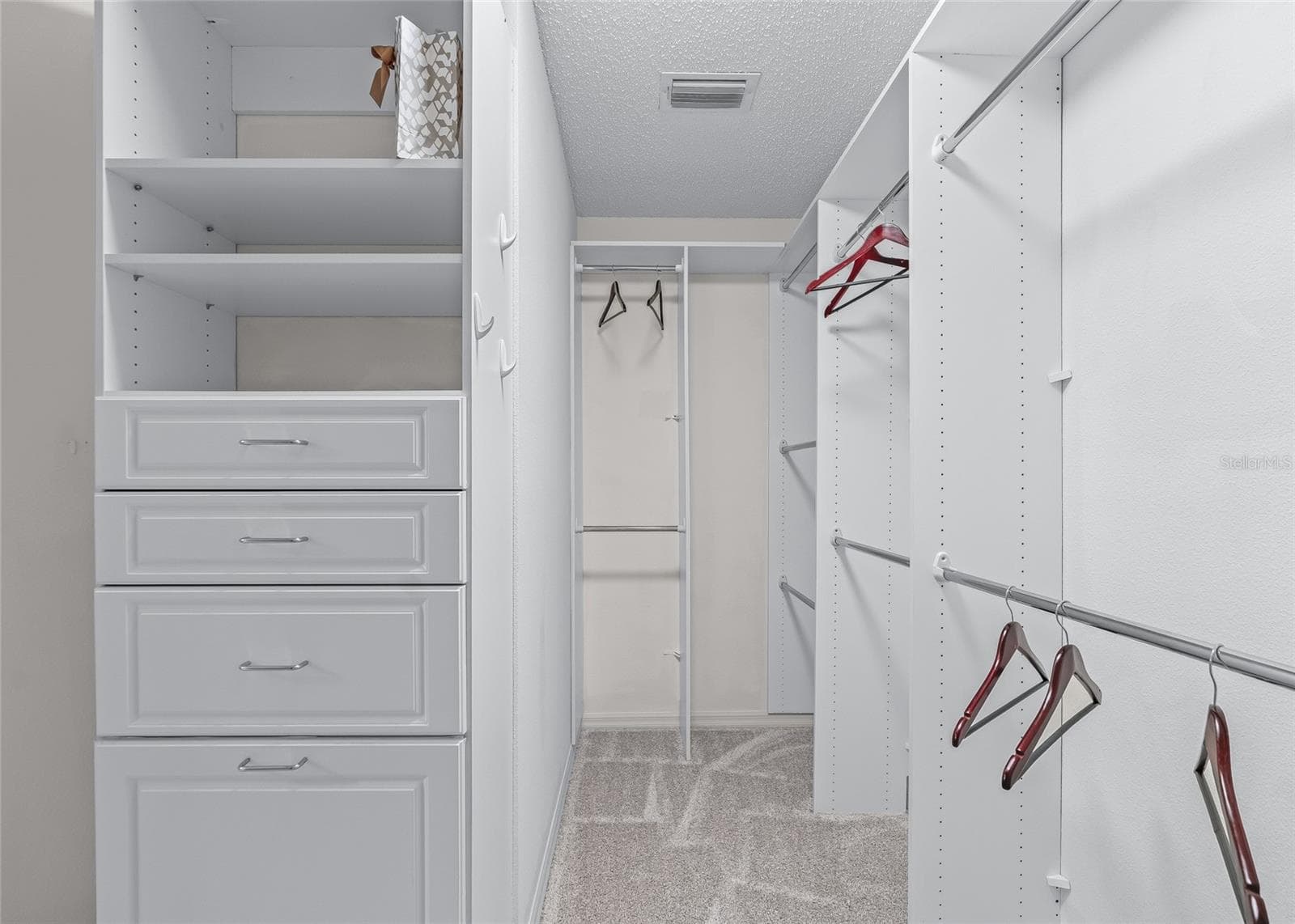 Another view of the impressive custom closet system shows abundant hanging space, adjustable shelving and built-in drawers. - 17601 SE 81ST TIMBERWOOD TER, THE VILLAGES