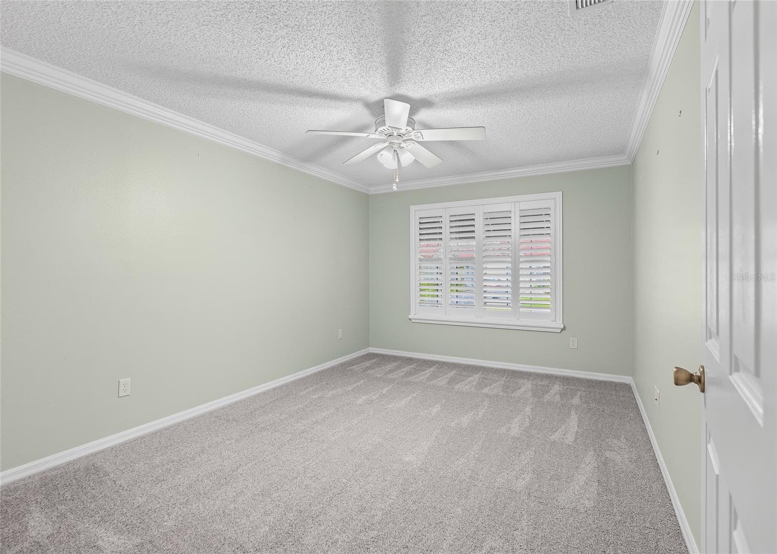 Comfortable Guest Bedroom with crown molding, plantation shutters, ceiling fan and BRAND-NEW plush carpeting. - 17601 SE 81ST TIMBERWOOD TER, THE VILLAGES