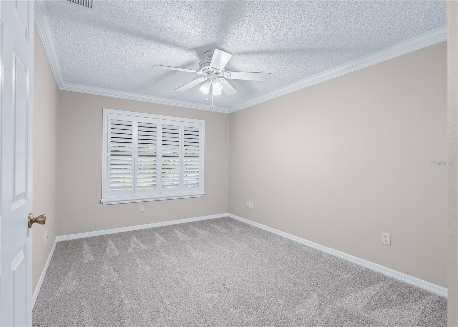 Spacious THIRD BEDROOM features crown molding, plantation shutters, ceiling fan and BRAND-NEW, never-lived-on plush carpeting. - 17601 SE 81ST TIMBERWOOD TER, THE VILLAGES