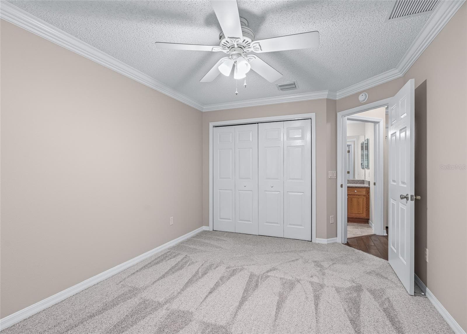 Another view highlights the generous size of the third bedroom, with a large closet, crown molding and fresh new carpeting—ideal for guests, an office or hobby space. - 17601 SE 81ST TIMBERWOOD TER, THE VILLAGES