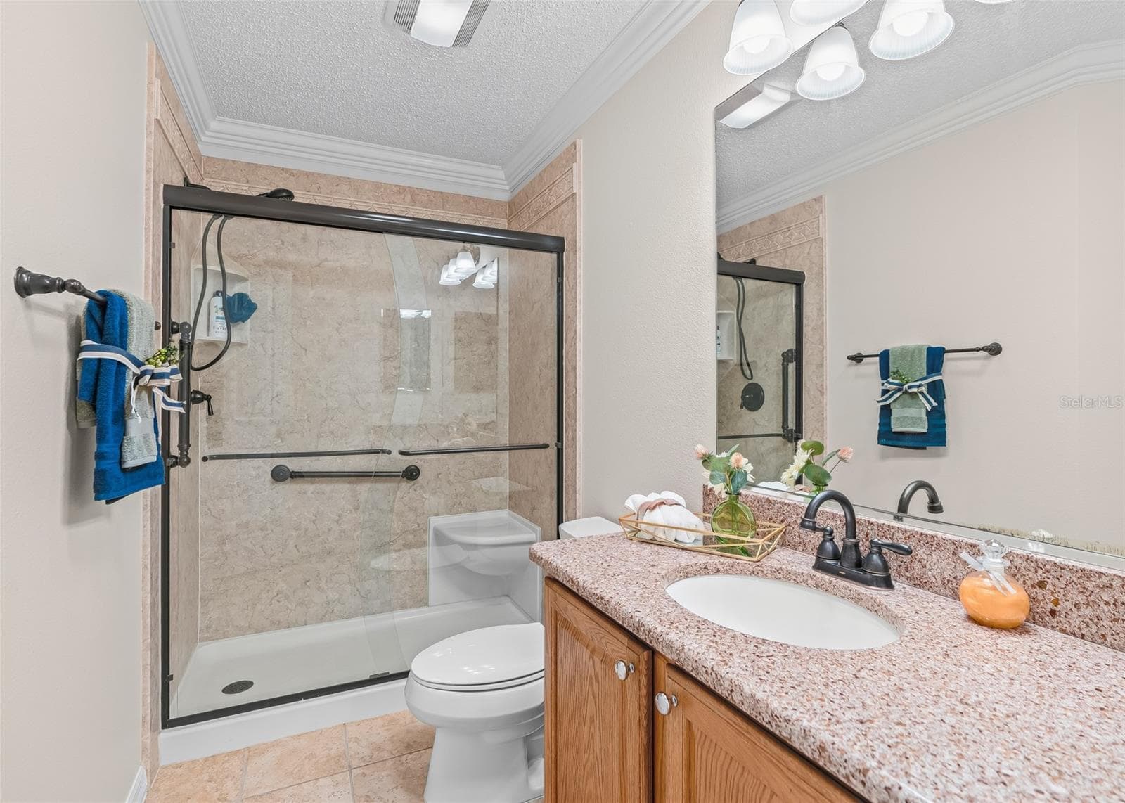 Closer view of the Guest Bath showcases the attractive UPDATED walk-in shower with glass doors, built-in seating and grab bars for added convenience. - 17601 SE 81ST TIMBERWOOD TER, THE VILLAGES