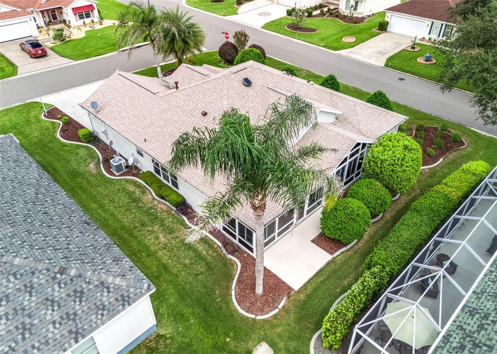 Rear aerial view highlights the enclosed Florida Room addition, surrounding landscaping and the home’s generous lot configuration. - 17601 SE 81ST TIMBERWOOD TER, THE VILLAGES