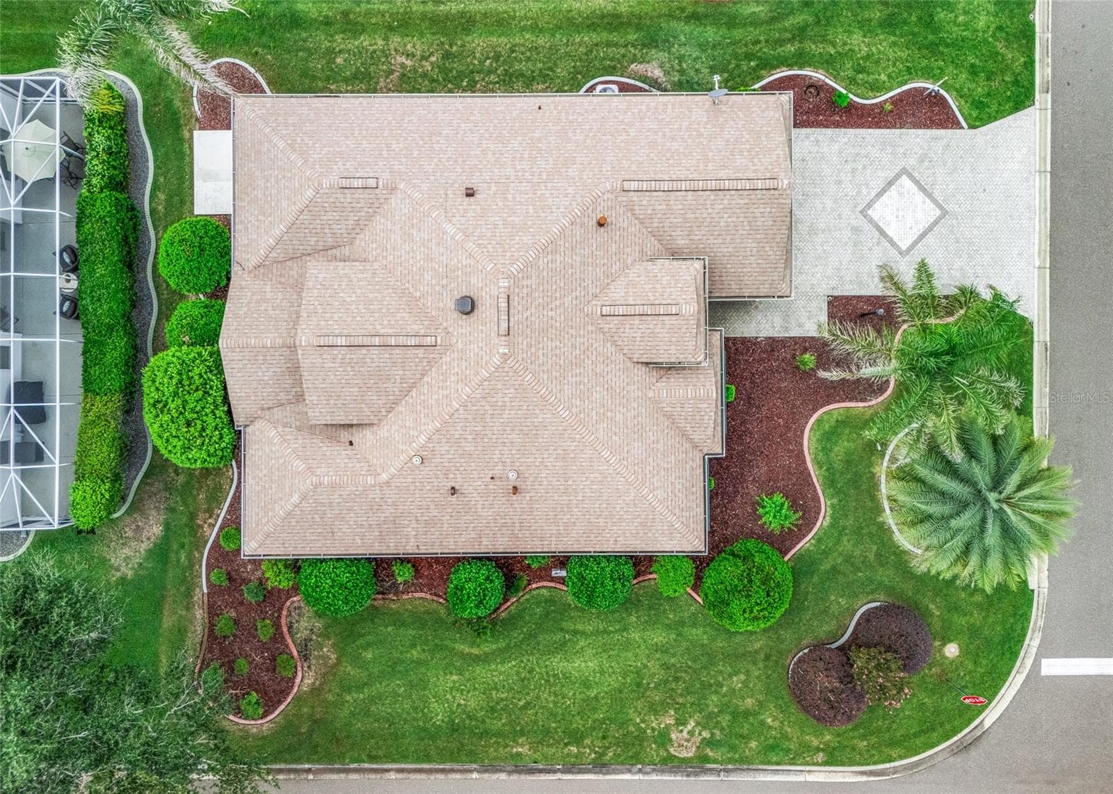 Top-down aerial clearly shows the home’s expansive footprint, landscaped corner lot, paver driveway and NEW 2024 ROOF. - 17601 SE 81ST TIMBERWOOD TER, THE VILLAGES