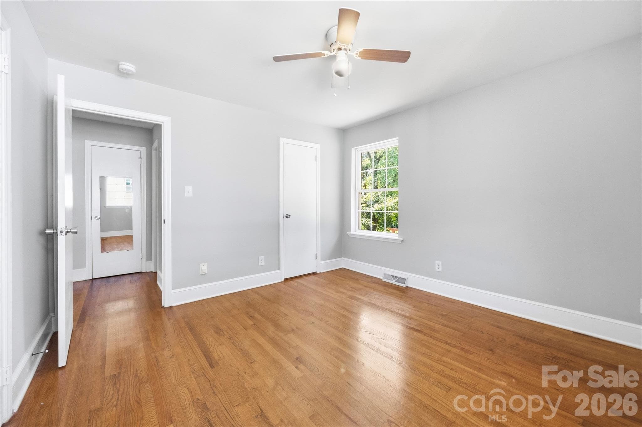 This photo of the primary bedroom shows a small door in the back right corner. That is the private powder room. The main door is open showing a mirrored door across the hall. That is a closet. - 6506 Candlewood Drive, Charlotte