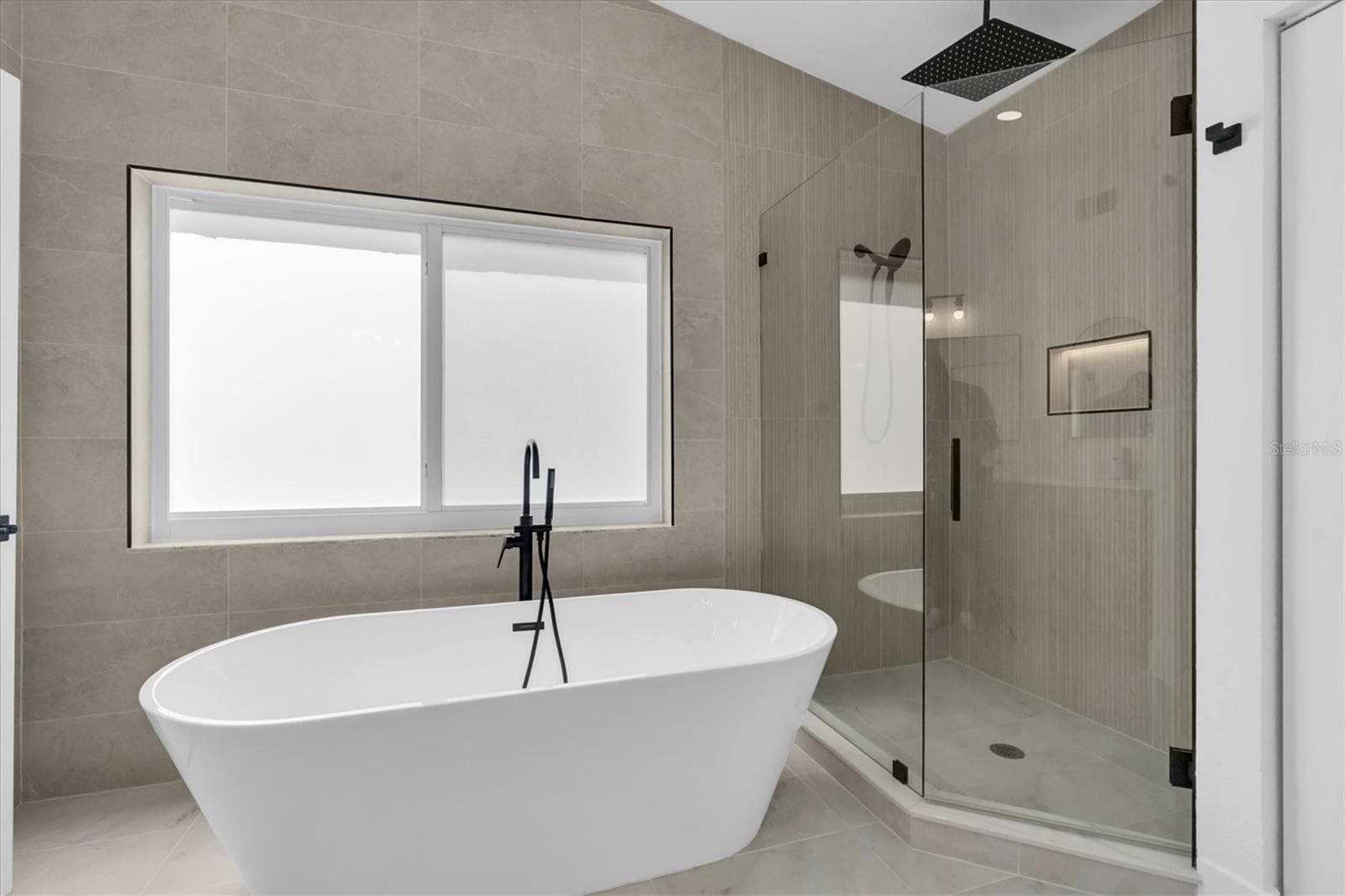 Spa-inspired primary bath with freestanding soaking tub and oversized walk-in shower. - 630 PINTA DR, TIERRA VERDE