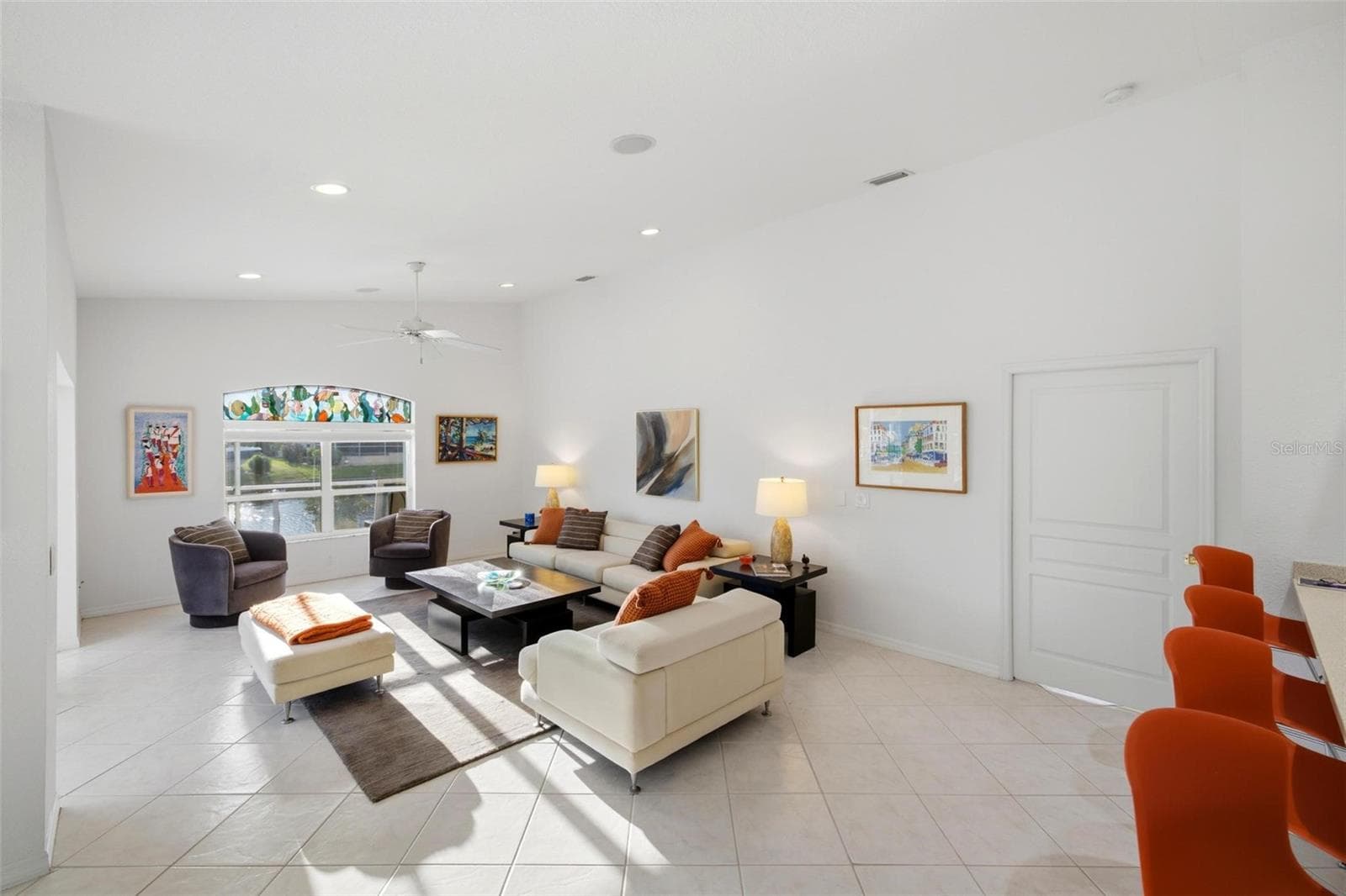 family room is very spacious and has a large slider, large window with a transom above it, which has a custom stained glass insert that lglows as the sun sets. - 209 DIVINCI DR, PUNTA GORDA