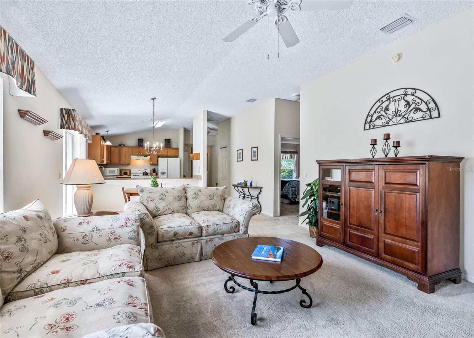 Bright and spacious open-concept living area designed for easy living and entertaining. The kitchen, dining, and living spaces flow seamlessly together, creating a comfortable and inviting gathering space with plenty of room for family and guests. - 17535 SE 84TH FOXGROVE AVE, THE VILLAGES