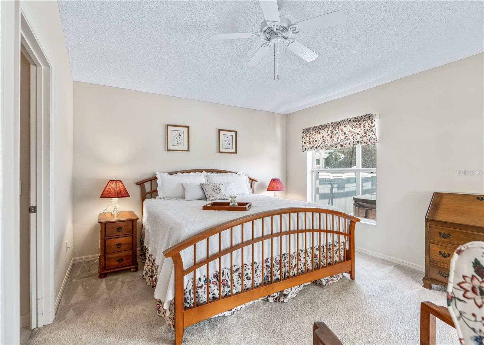 Spacious primary bedroom featuring a private ensuite bathroom, large walk-in closet, and sliding door access to the enclosed lanai. The bright, comfortable space offers a wonderful retreat with convenient access to the beautiful outdoor living area. - 17535 SE 84TH FOXGROVE AVE, THE VILLAGES