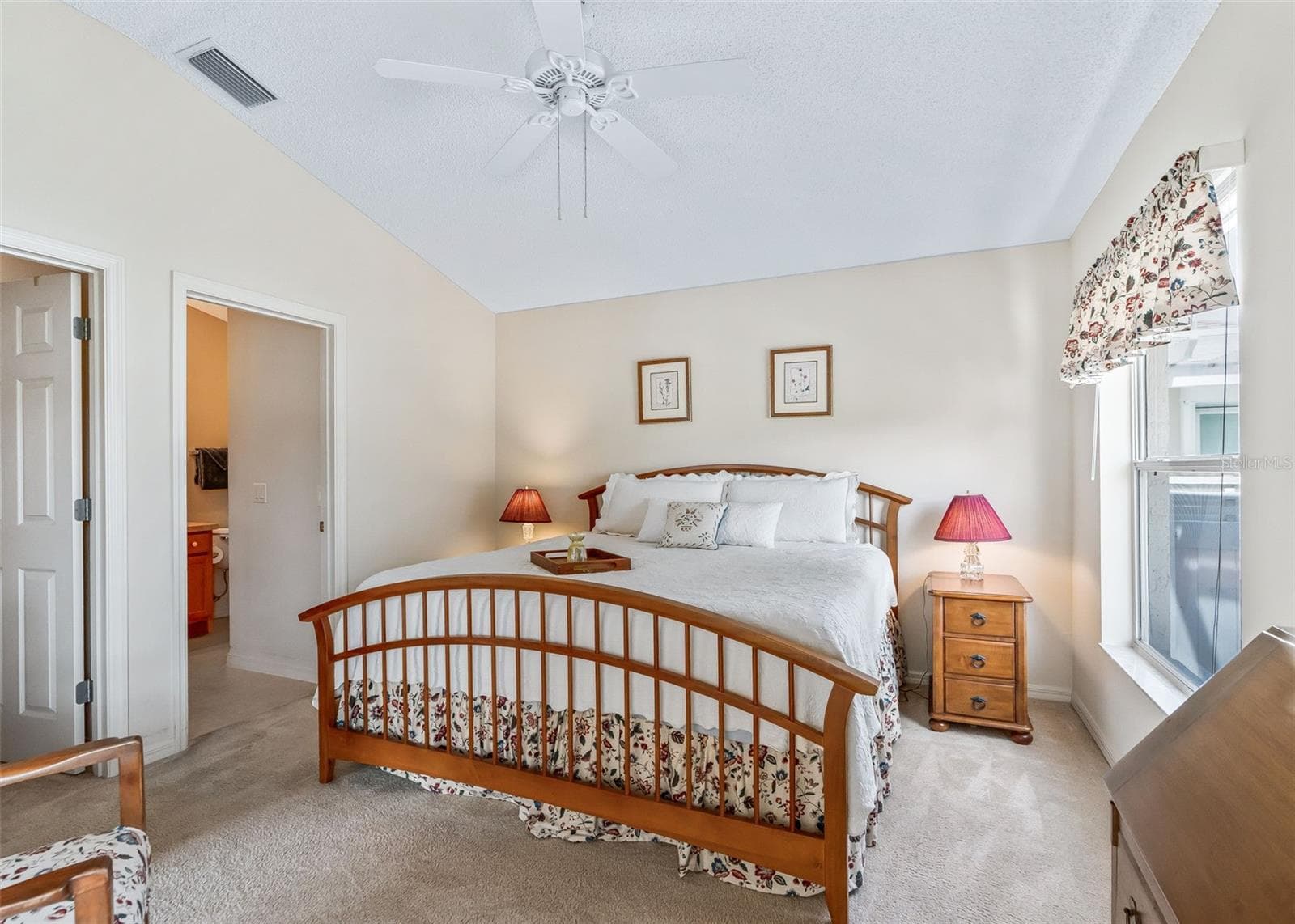 Bright and inviting primary bedroom featuring a ceiling fan for added comfort and relaxation. This spacious retreat offers a peaceful setting to unwind and rest while enjoying beautiful views overlooking the golf course. - 17535 SE 84TH FOXGROVE AVE, THE VILLAGES