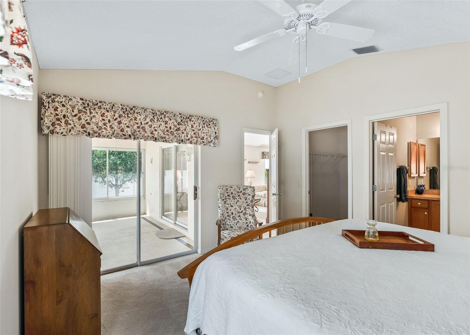 Bright and inviting primary bedroom featuring sliding door access to the enclosed lanai, creating a seamless indoor-outdoor living experience. Relax and unwind while enjoying gorgeous golf course views from the comfort of your own bedroom. - 17535 SE 84TH FOXGROVE AVE, THE VILLAGES