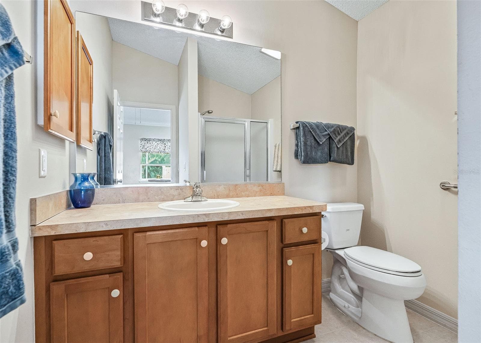 Beautiful ensuite primary bathroom featuring Autumn Maple cabinetry that continues the warm, inviting style of the home. The thoughtful design provides both comfort and functionality. - 17535 SE 84TH FOXGROVE AVE, THE VILLAGES