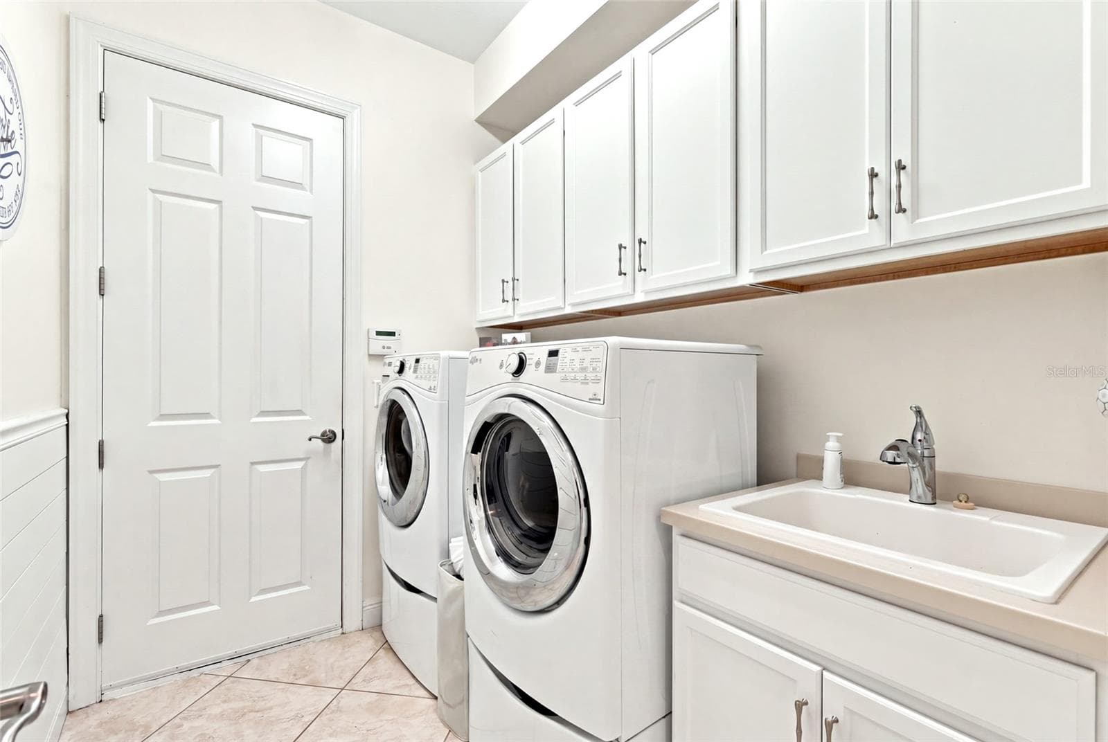 interior laundry room full size washer/dryer cabinetry and laundy sink - 5057 LAKE OVERLOOK AVE, BRADENTON