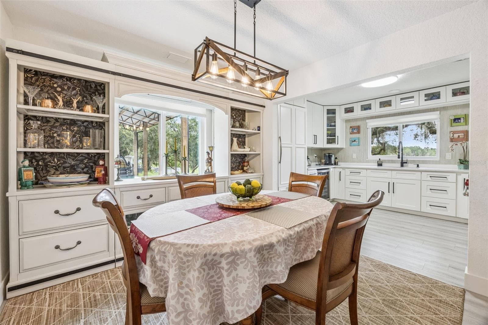 Elegant dining area featuring a built-in china hutch, flowing seamlessly into the updated kitchen. - 1476 SPRING LAKE RD, FRUITLAND PARK