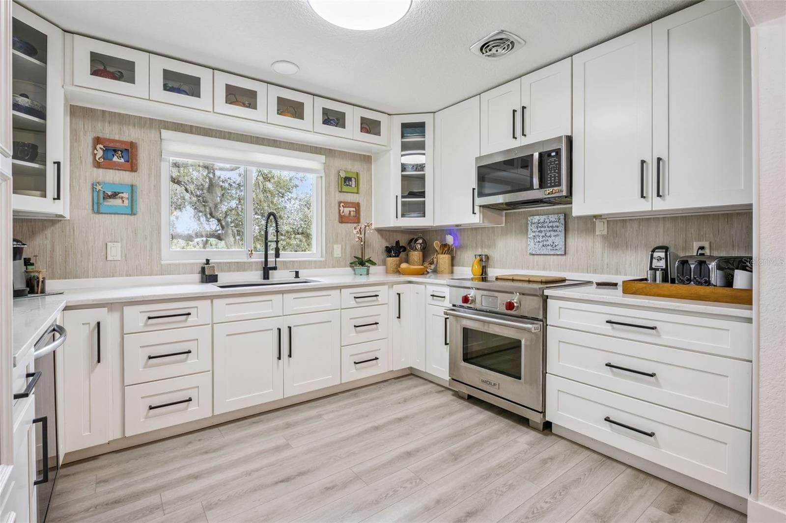 Chef-inspired kitchen with a professional-grade range, quartz countertops, and crisp white shaker cabinetry. - 1476 SPRING LAKE RD, FRUITLAND PARK