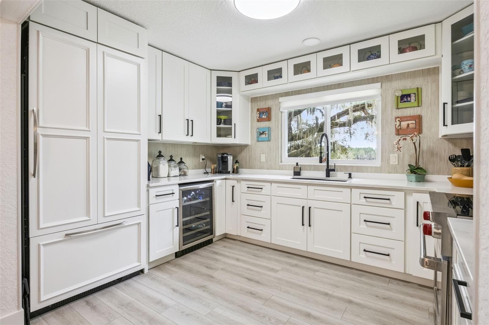 Thoughtfully appointed kitchen with a built-in wine cooler, panel-ready refrigerator, and generous counter space for meal prep and gathering. - 1476 SPRING LAKE RD, FRUITLAND PARK
